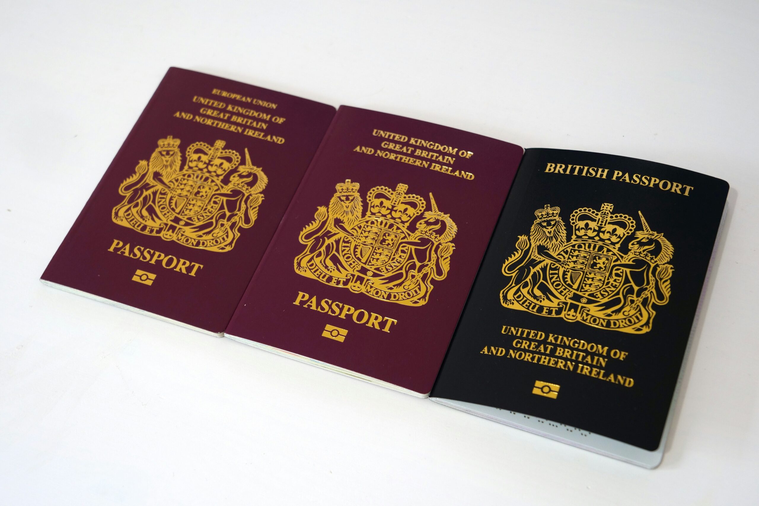 Three UK passports in different colours